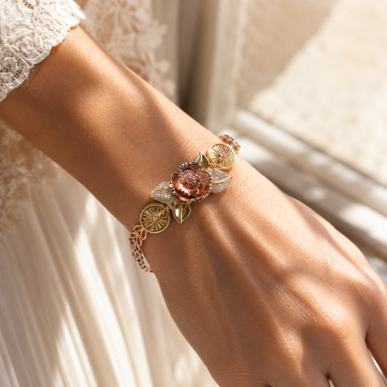 Women's gold charm bracelet worn in warm sunlight